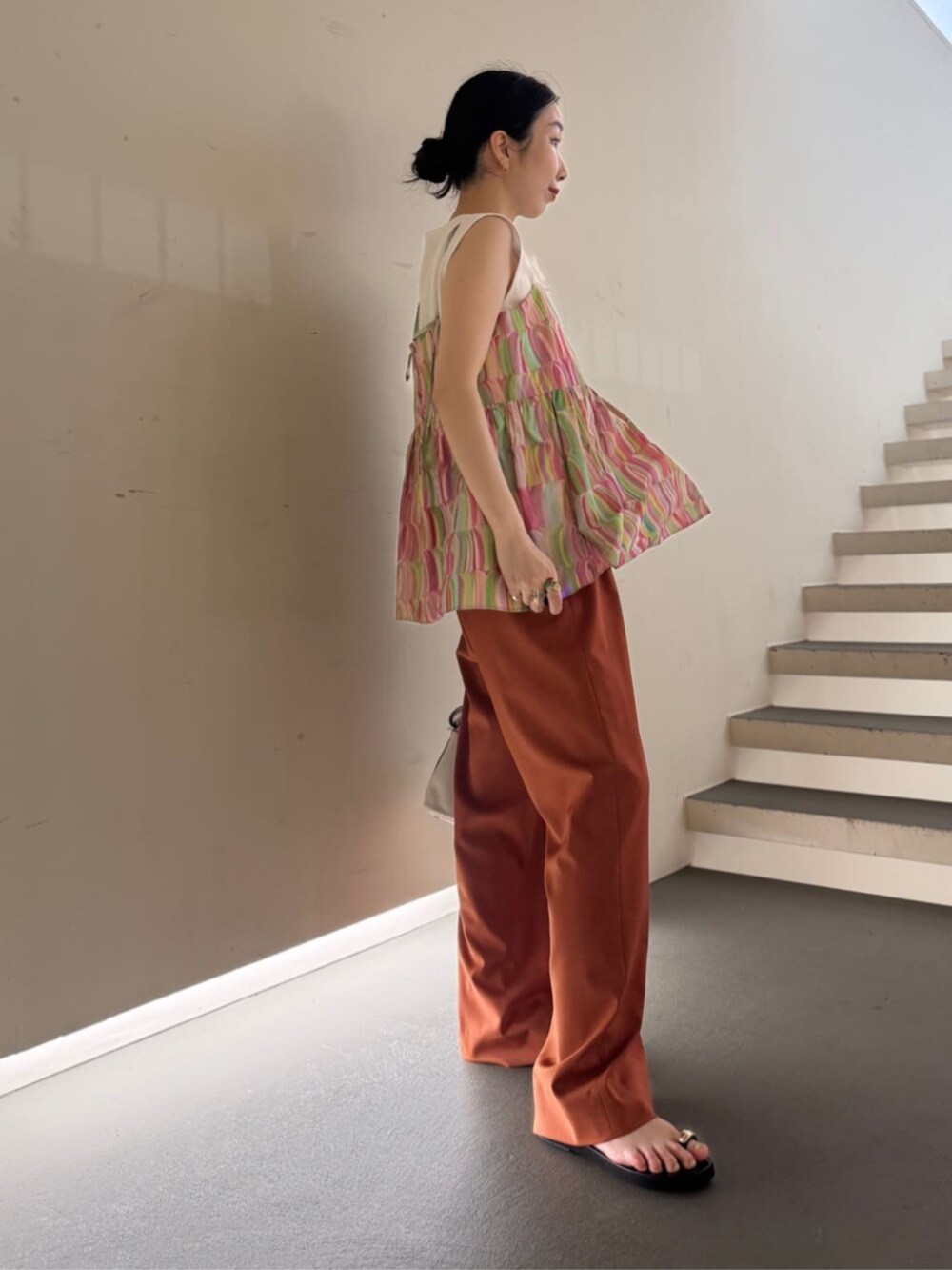 ホワイト系のキャミソール、ホワイト系のショルダーバッグ、イエロー系のスラックスを着用したレディースの夏コーディネートの4枚目の写真