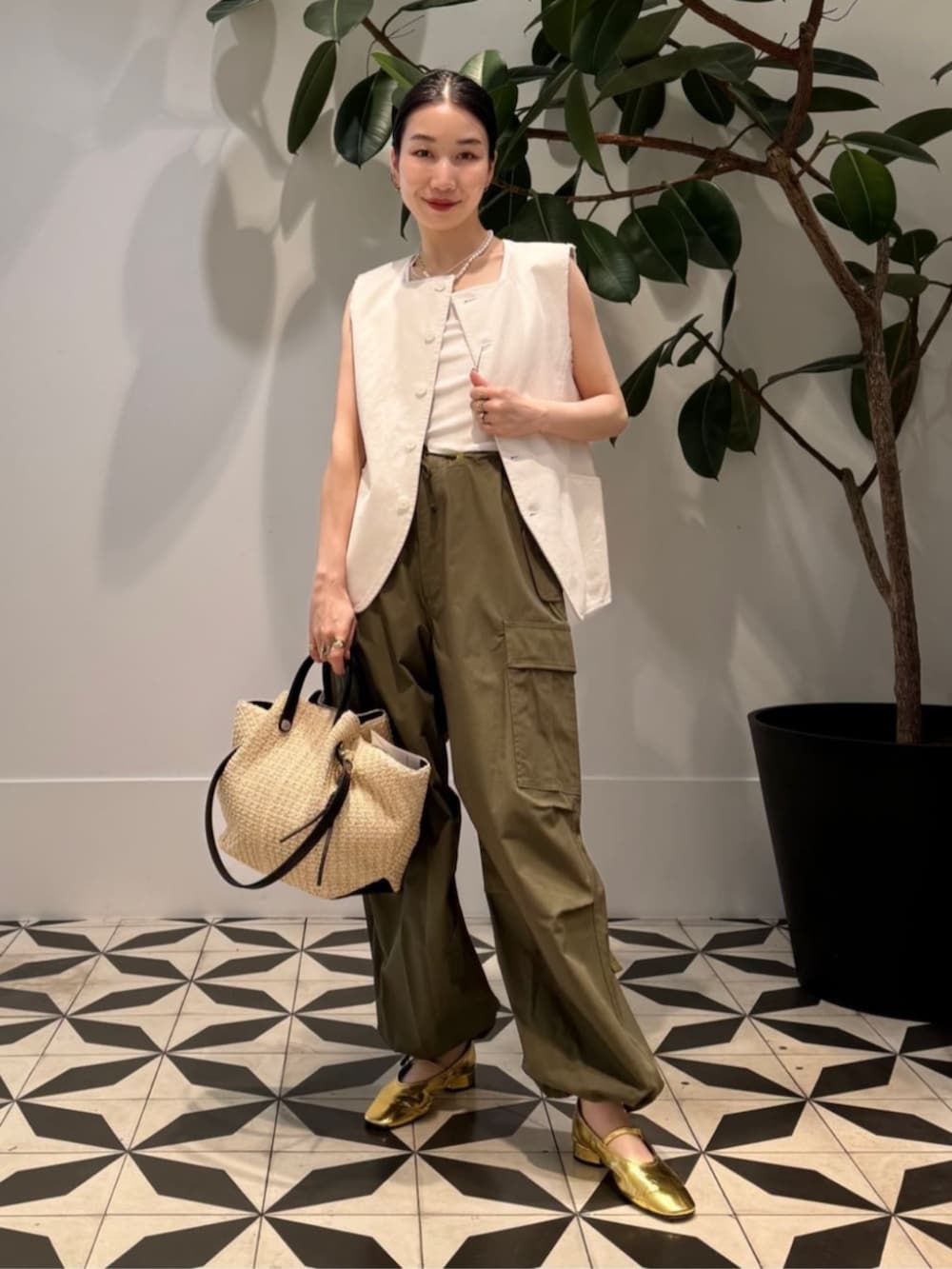 ホワイト系のタンクトップ、ベージュ系のかごバッグ、ホワイト系のキャミソールを着用したレディースの夏コーディネートの2枚目の写真