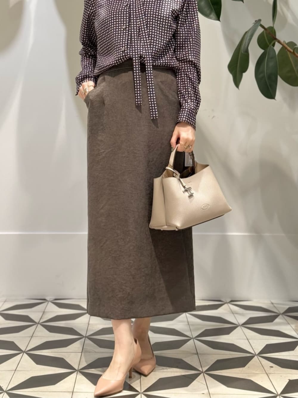 ブラック系のキャミソール、ブルー系のピーコート、ブラウン系のテーラードジャケットを着用したレディースの冬コーディネートの6枚目の写真