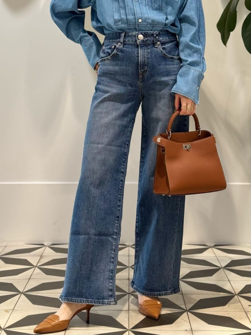 ホワイト系のキャミソール、ブルー系のデニムパンツ、レッド系のノーカラージャケットを着用したレディースの秋コーディネートの5枚目の写真