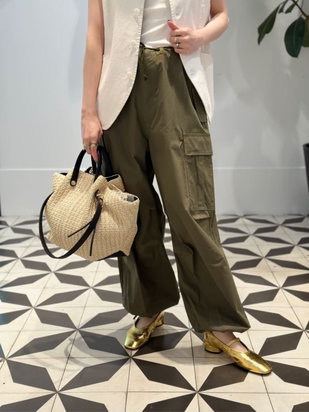 ホワイト系のタンクトップ、ベージュ系のかごバッグ、ホワイト系のキャミソールを着用したレディースの夏コーディネートの4枚目の写真