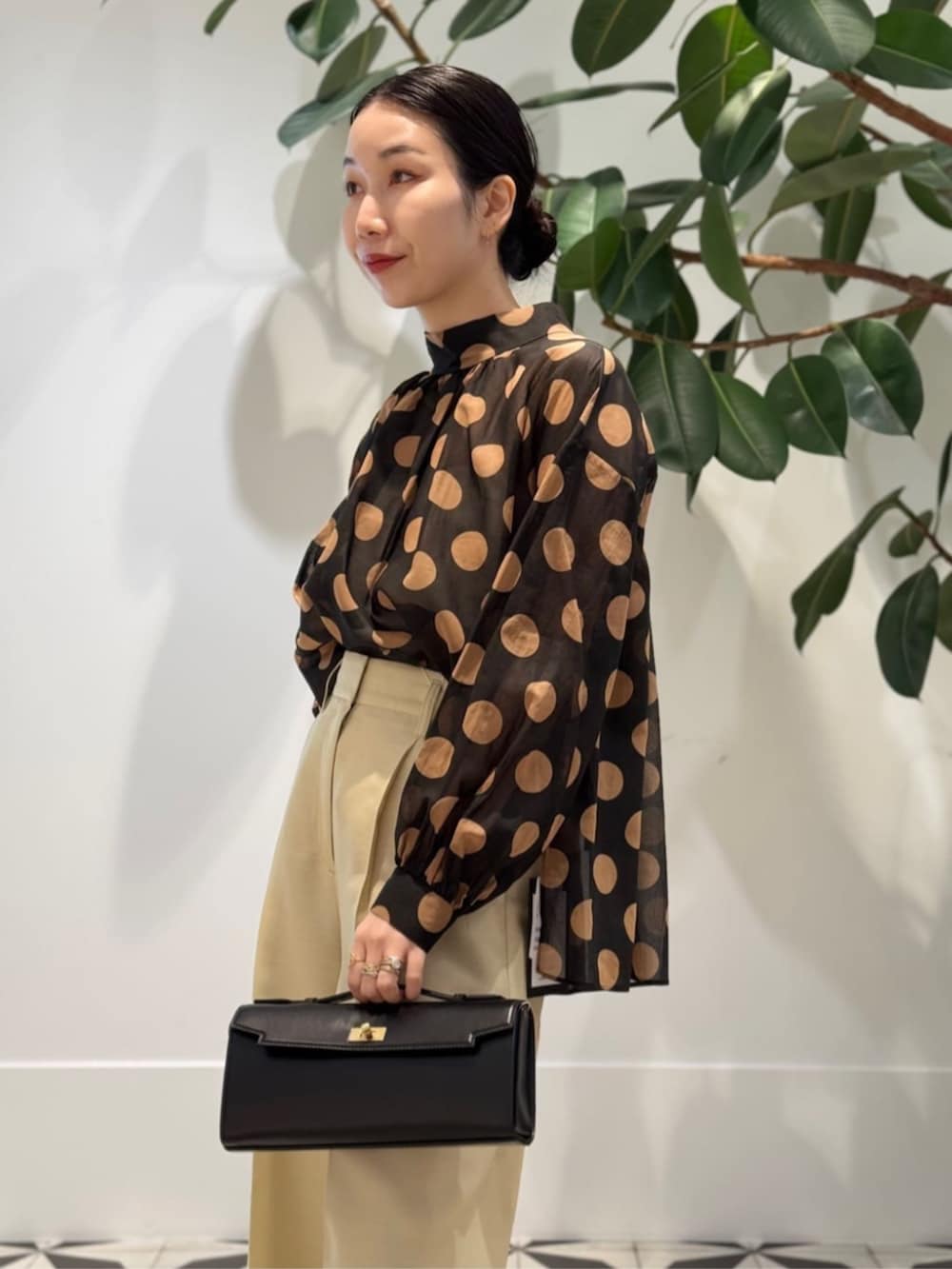 イエロー系のスラックス、ホワイト系のキャミソール、ブラック系のシャツ/ブラウスを着用したレディースの夏コーディネートの3枚目の写真