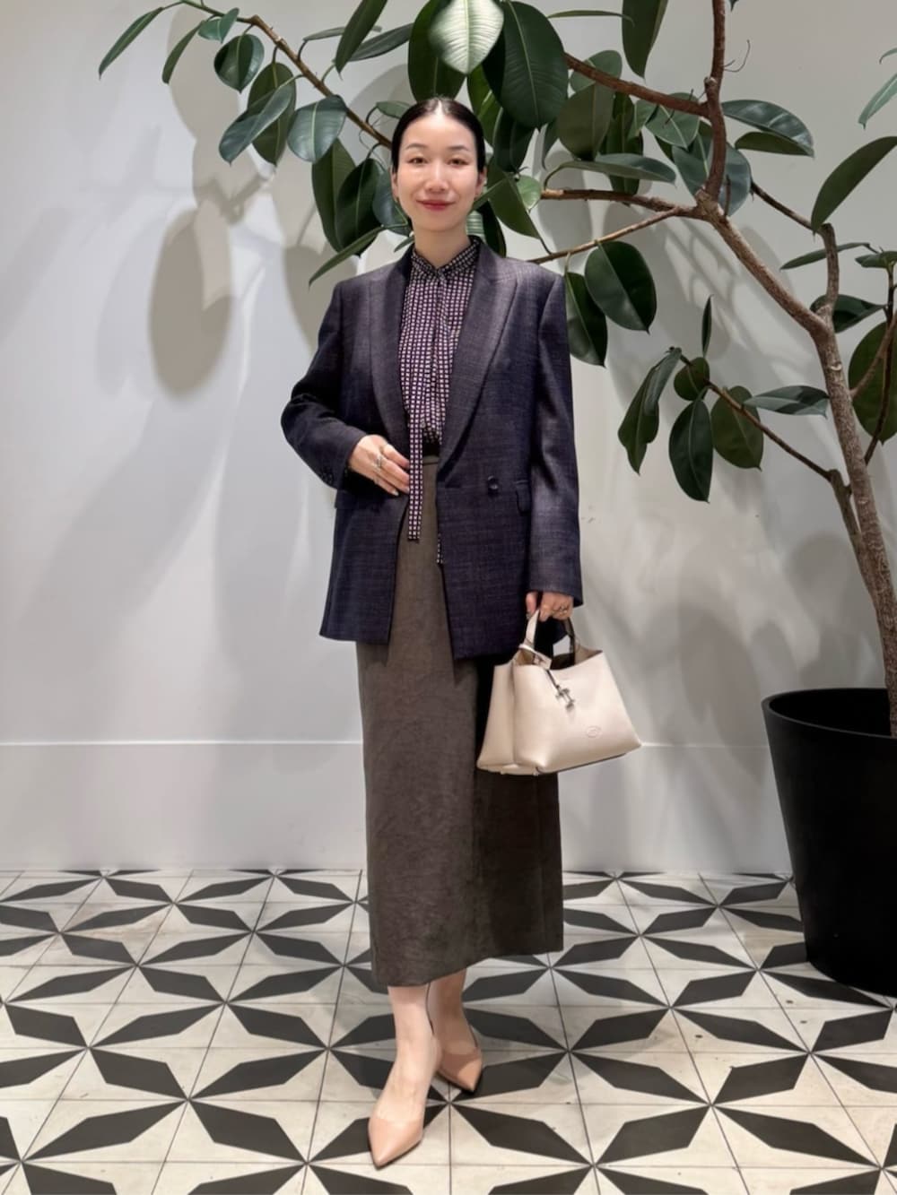 ブラック系のキャミソール、ブルー系のピーコート、ブラウン系のテーラードジャケットを着用したレディースの冬コーディネートの2枚目の写真