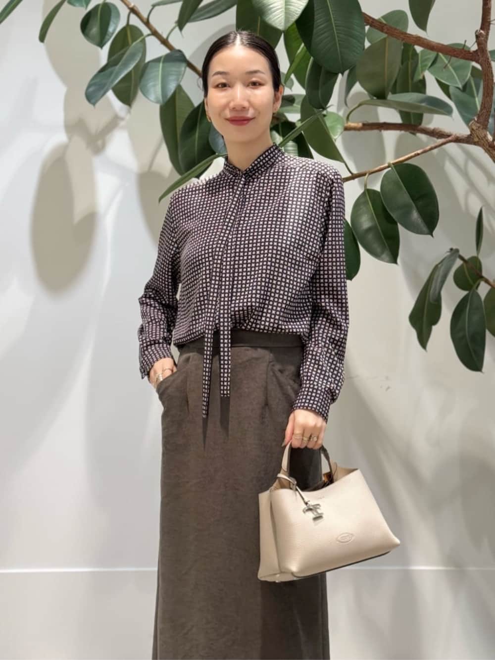 ブラック系のキャミソール、ブルー系のピーコート、ブラウン系のテーラードジャケットを着用したレディースの冬コーディネートの5枚目の写真