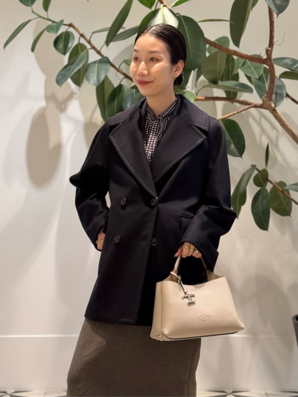 ブラック系のキャミソール、ブルー系のピーコート、ブラウン系のテーラードジャケットを着用したレディースの冬コーディネートの4枚目の写真