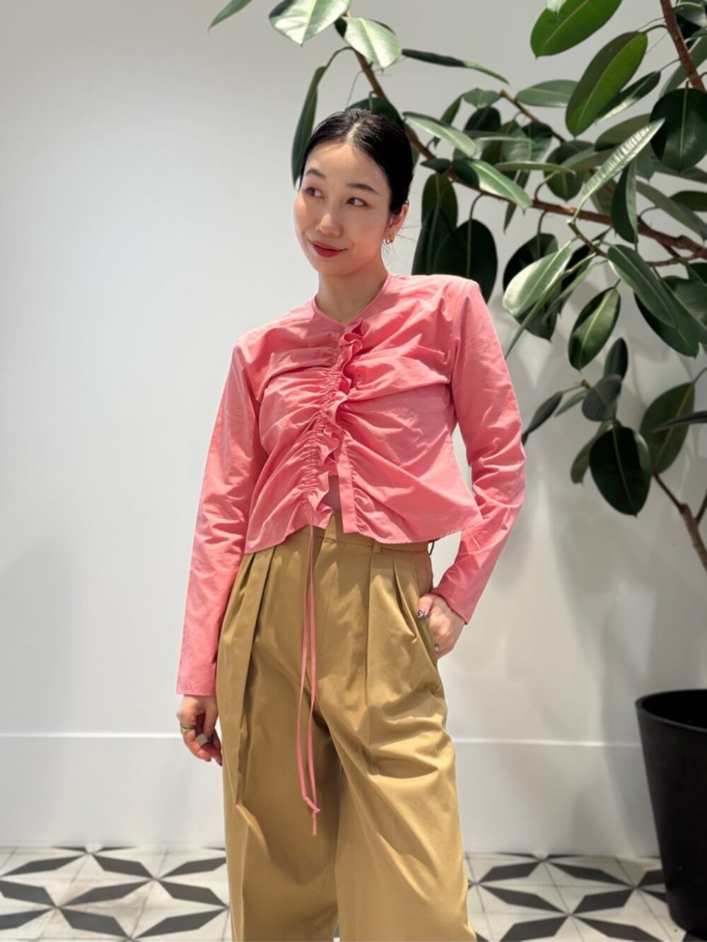 ベージュ系のチノパンツ、イエロー系のハンドバッグ、オレンジ系のカーディガン/ボレロを着用したレディースの春コーディネートの3枚目の写真