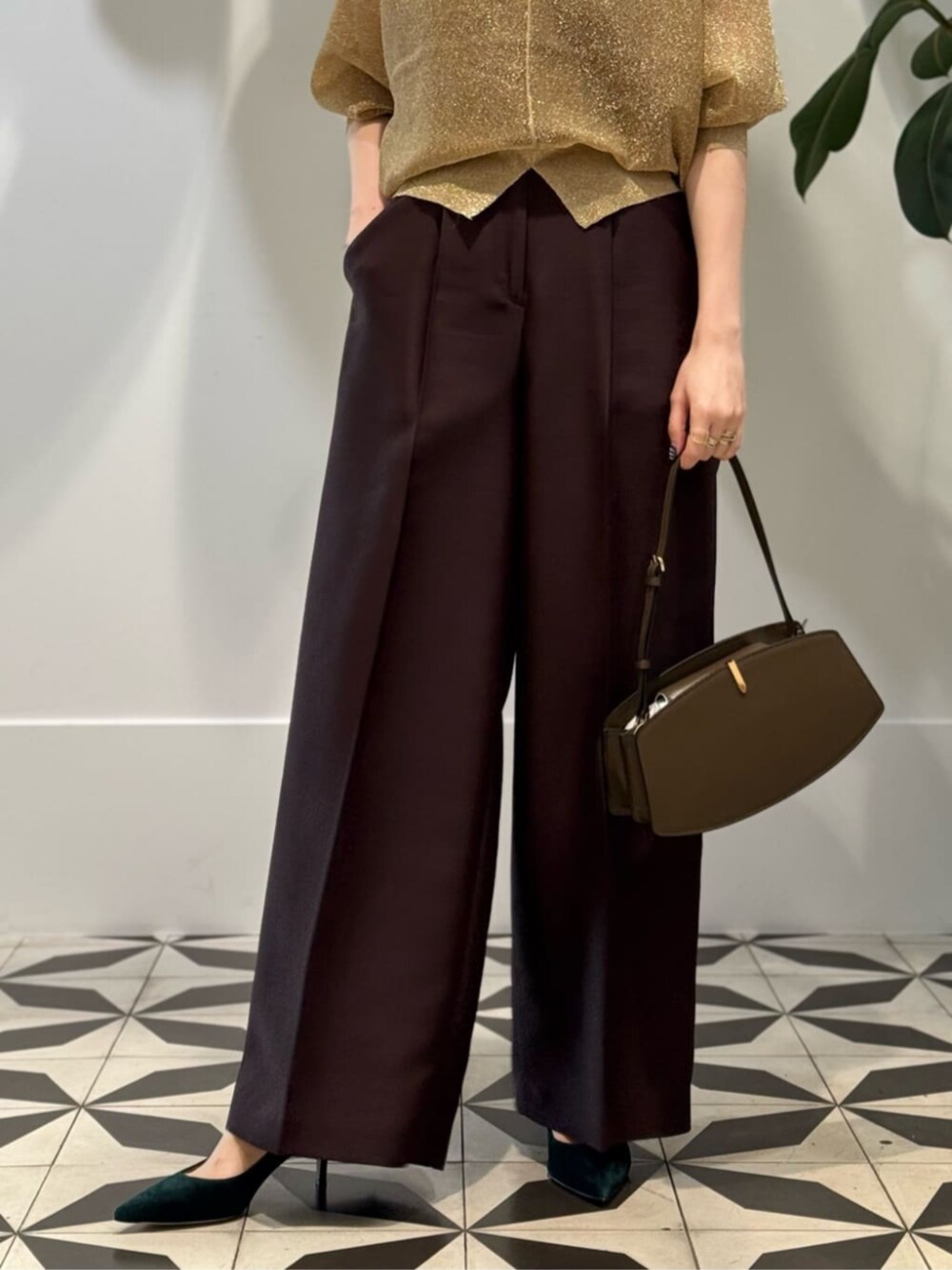 イエロー系のスラックス、グレー系のキャミソール、ゴールド系のニット/セーターを着用したレディースの夏コーディネートの3枚目の写真