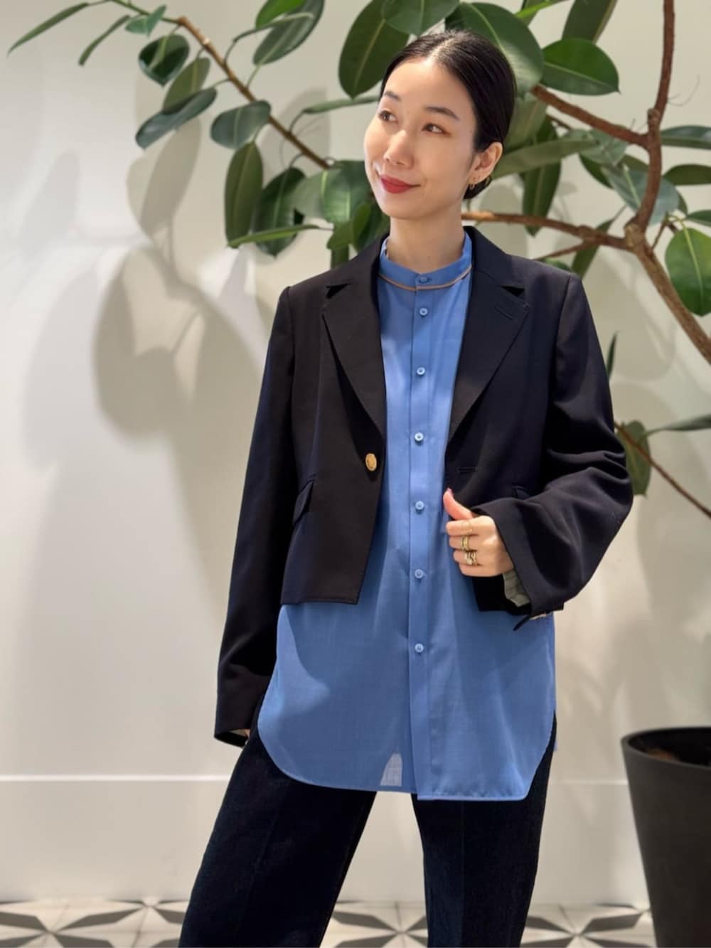 ブルー系のデニムパンツ、ホワイト系のキャミソール、ブルー系のテーラードジャケットを着用したレディースの夏コーディネートの2枚目の写真