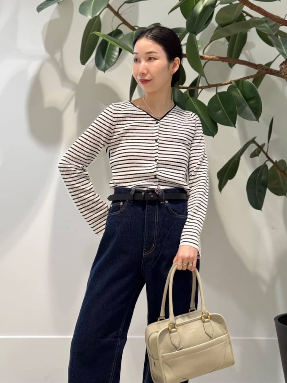 ホワイト系のキャミソール、ブラック系のサンダル、ブルー系のデニムパンツを着用したレディースの夏コーディネートの2枚目の写真