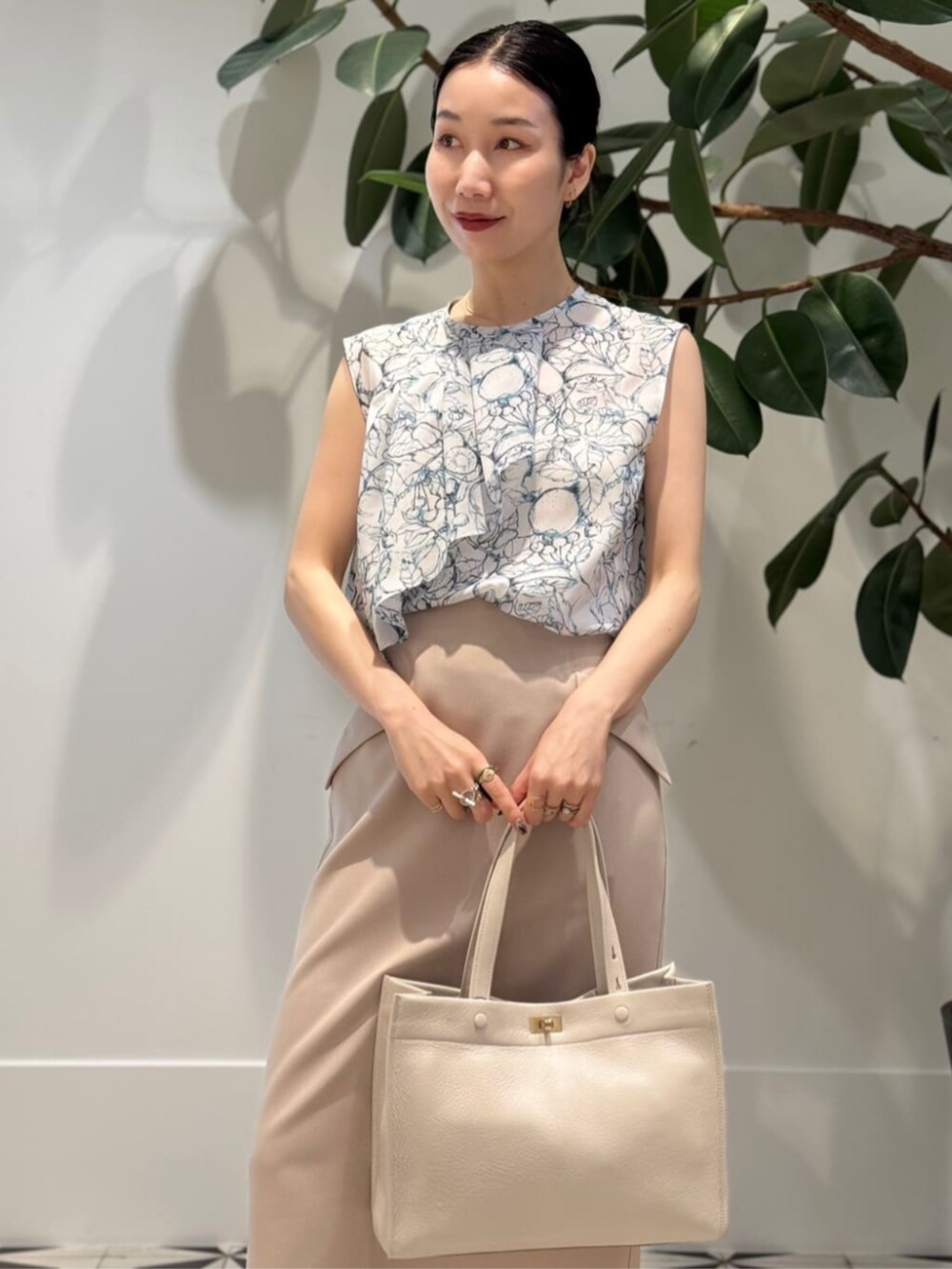 ホワイト系のキャミソール、ホワイト系のシャツ/ブラウス、ベージュ系のスカートを着用したレディースの夏コーディネートの2枚目の写真