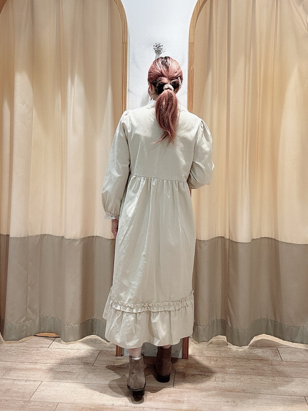 ホワイト系のワンピース、ホワイト系のTシャツ/カットソー、ベージュ系のブーツを着用したレディースの冬コーディネートの3枚目の写真