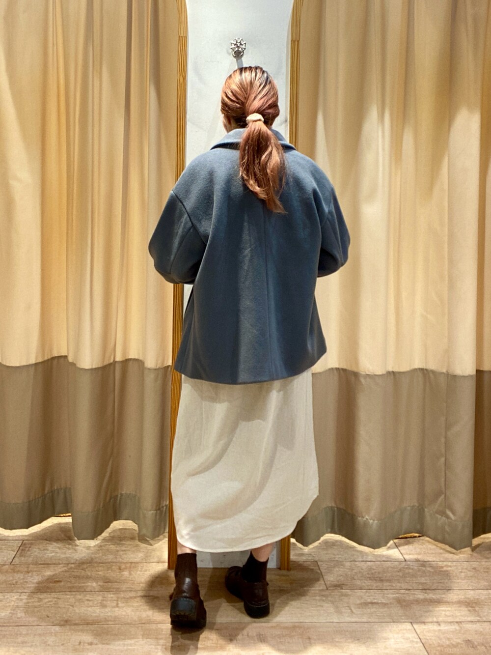 グレー系のベスト、ホワイト系のワンピース、ブラウン系のその他シューズを着用したレディースの秋コーディネートの3枚目の写真