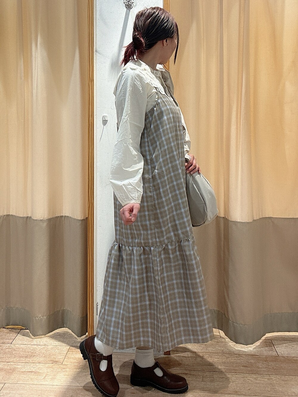 ホワイト系のシャツ/ブラウス、ベージュ系のワンピース、ホワイト系のハンドバッグを着用したレディースの春コーディネートの2枚目の写真