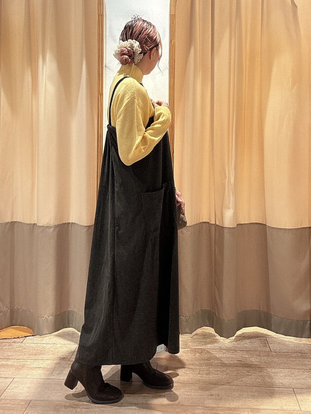 イエロー系のニット/セーター、グレー系のワンピース、ブラウン系のドレスシューズを着用したレディースの冬コーディネートの2枚目の写真