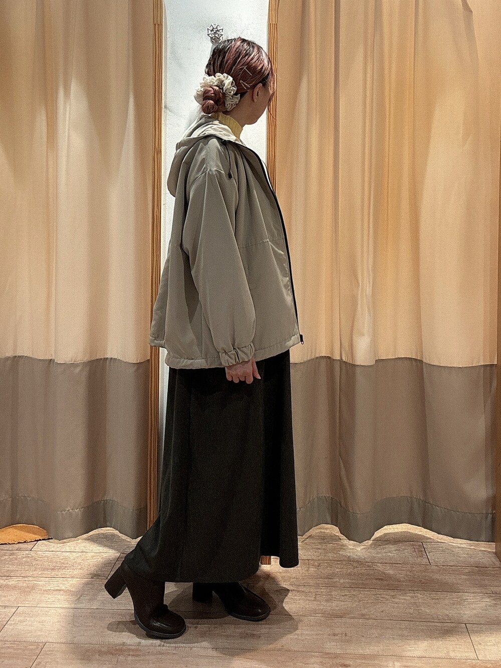 イエロー系のニット/セーター、グレー系のワンピース、ブラウン系のドレスシューズを着用したレディースの冬コーディネートの2枚目の写真