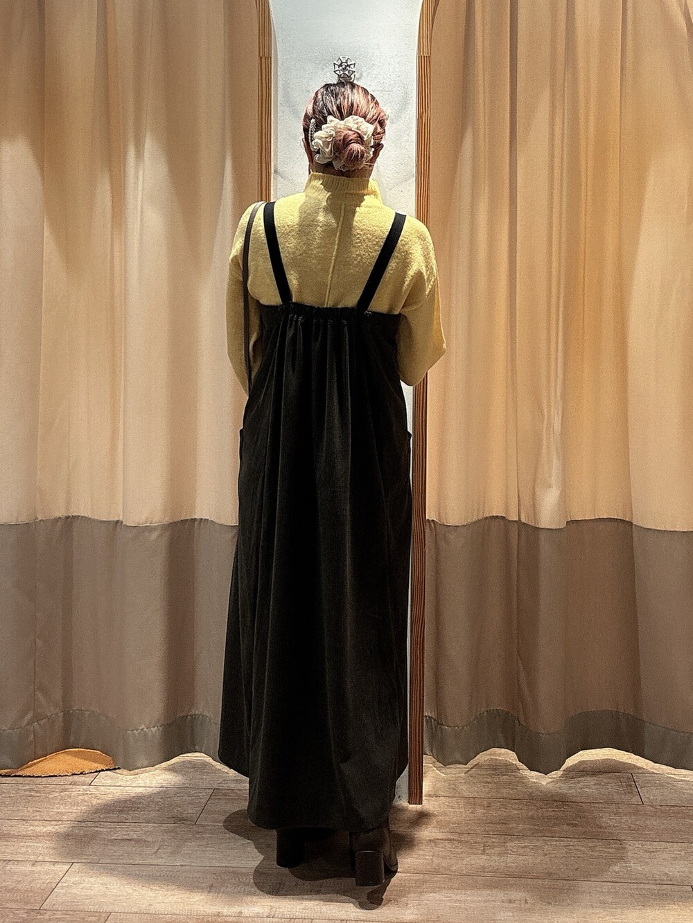 イエロー系のニット/セーター、グレー系のワンピース、ブラウン系のドレスシューズを着用したレディースの冬コーディネートの3枚目の写真