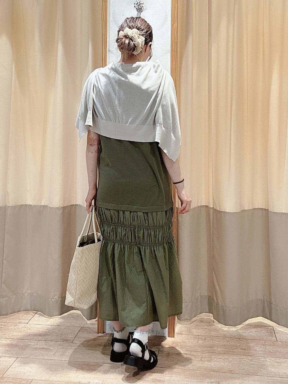 グリーン系のワンピース、グレー系のカーディガン/ボレロ、ホワイト系のハンドバッグを着用したレディースの夏コーディネートの3枚目の写真