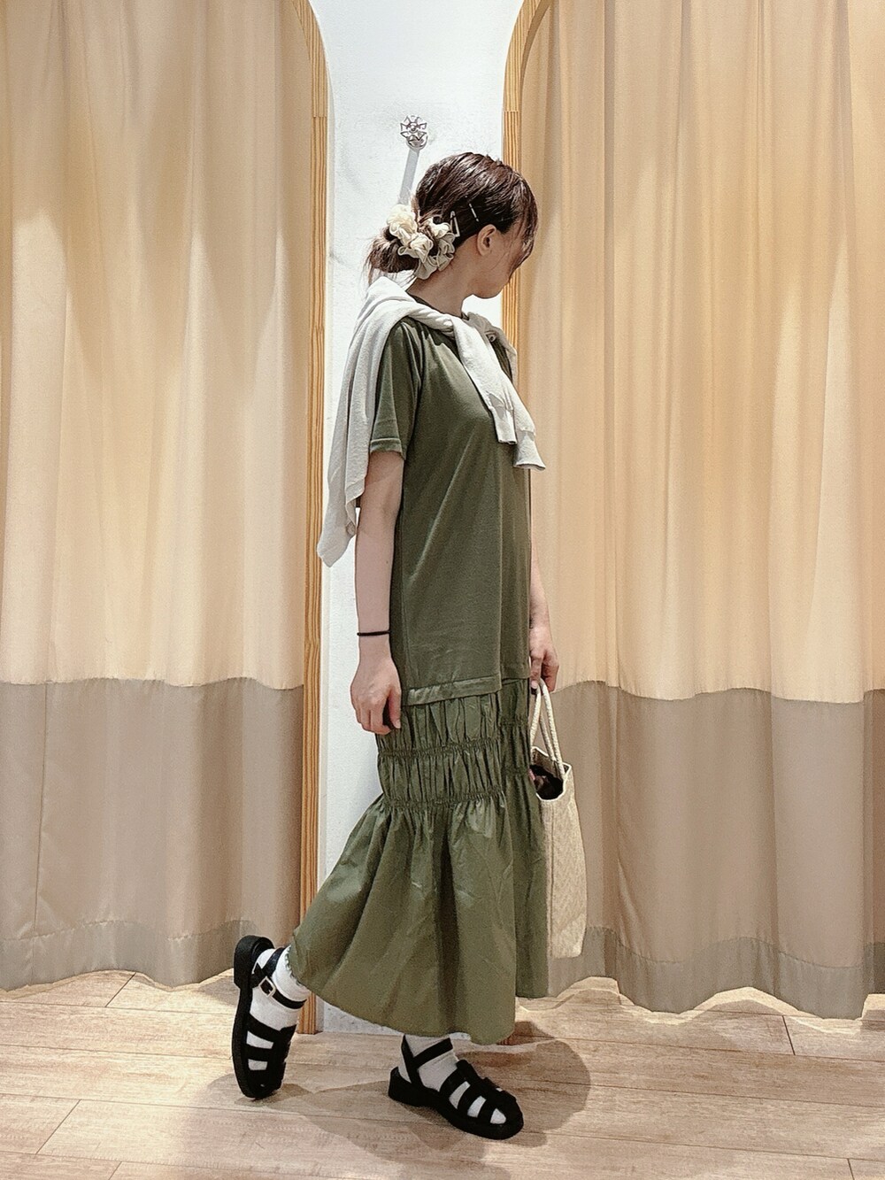 グリーン系のワンピース、グレー系のカーディガン/ボレロ、ホワイト系のハンドバッグを着用したレディースの夏コーディネートの2枚目の写真