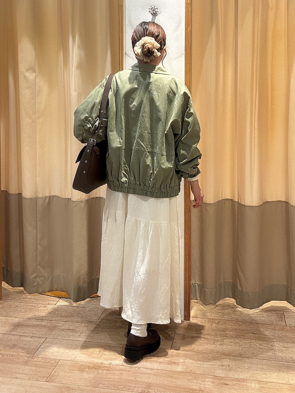 ホワイト系のワンピース、ブラウン系のその他シューズ、グリーン系のブルゾンを着用したレディースの春コーディネートの2枚目の写真