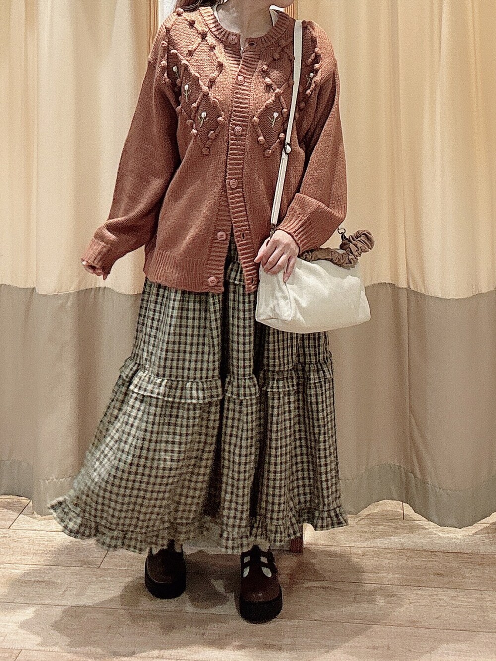 レッド系のカーディガン/ボレロ、レッド系のスカート、ブラウン系のその他シューズを着用したレディースの秋コーディネートの2枚目の写真