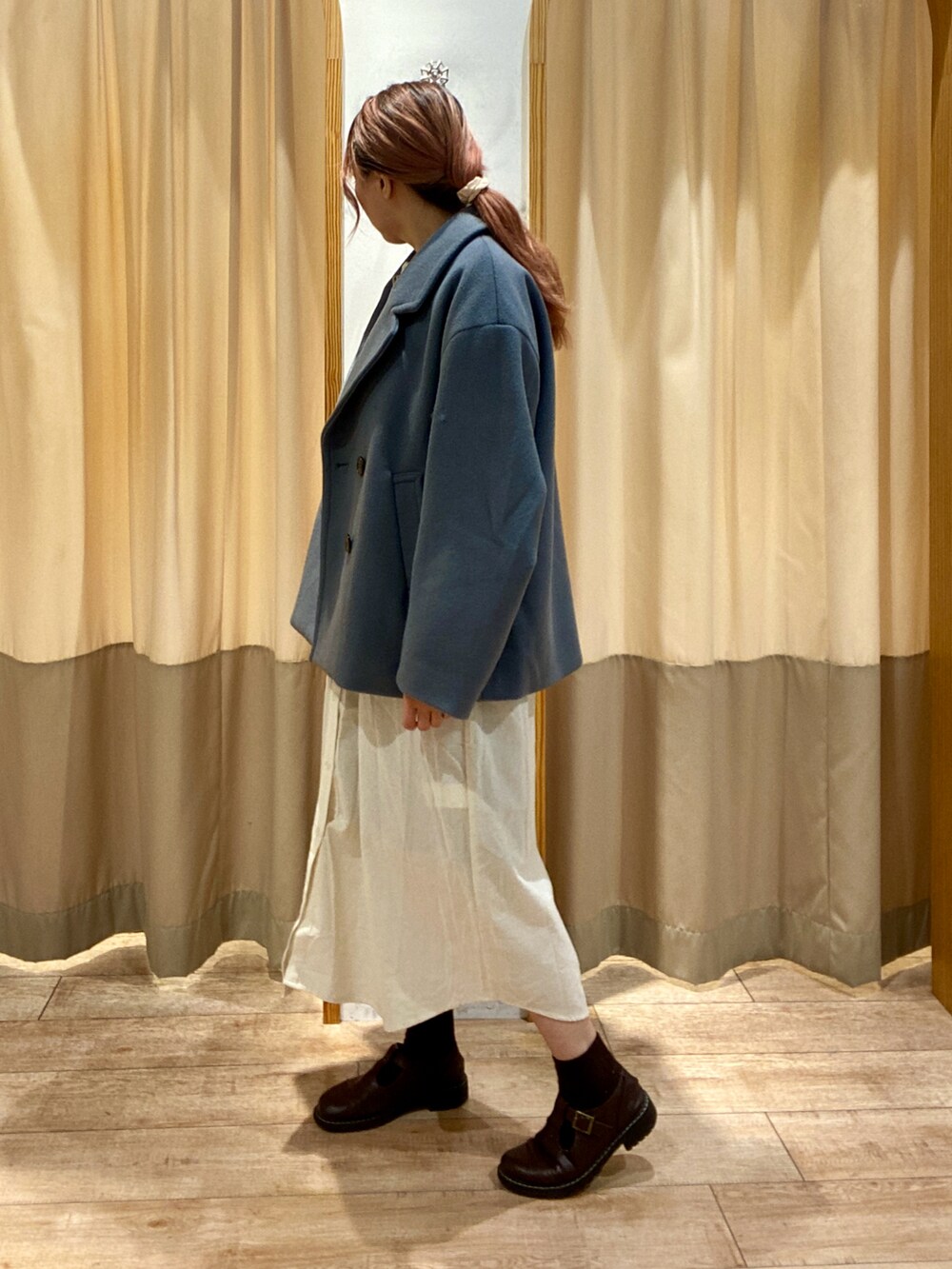 グレー系のベスト、ホワイト系のワンピース、ブラウン系のその他シューズを着用したレディースの秋コーディネートの2枚目の写真