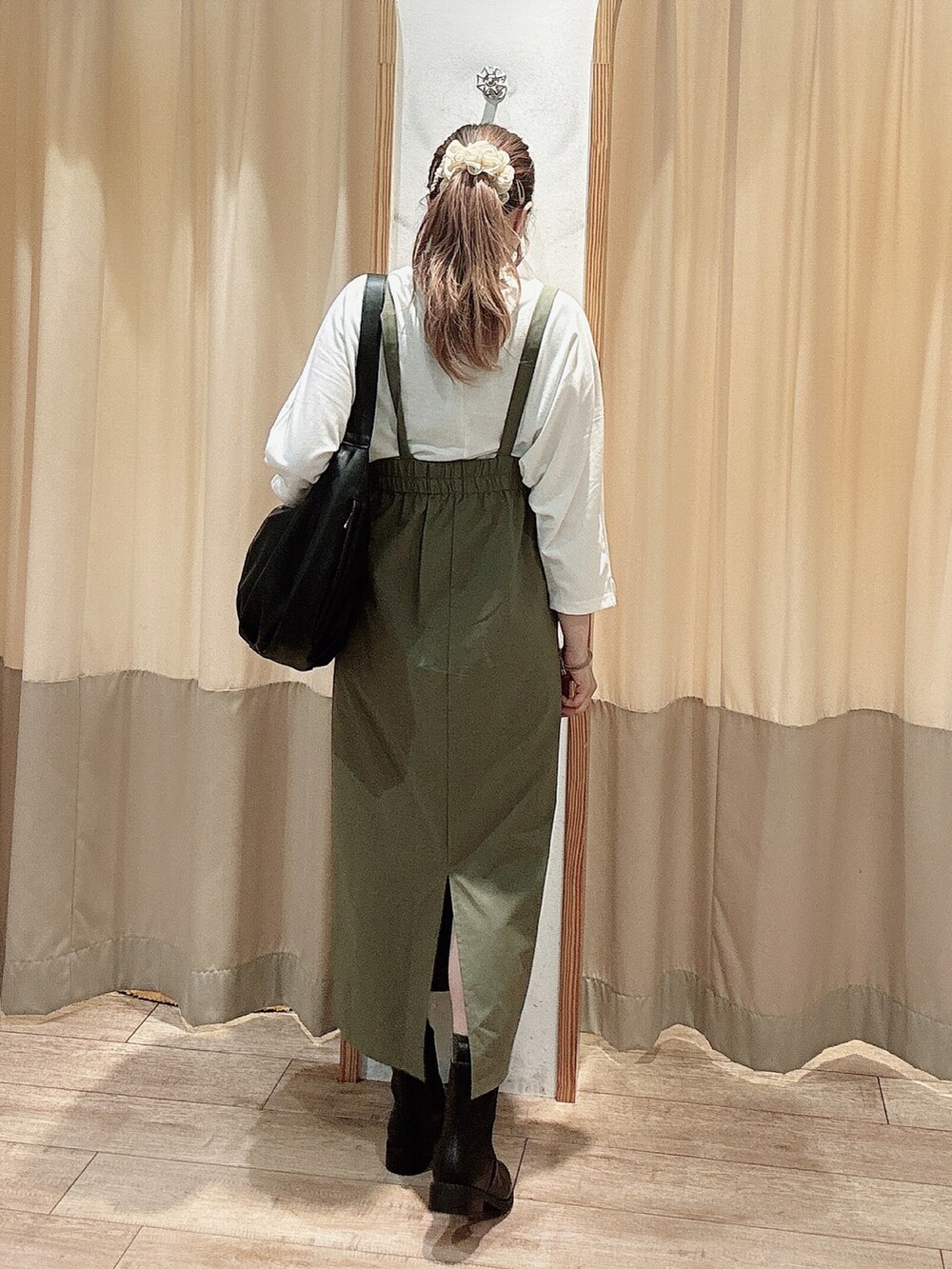 ホワイト系のTシャツ/カットソー、グリーン系のスカート、ブラック系のブーツを着用したレディースの秋コーディネートの2枚目の写真