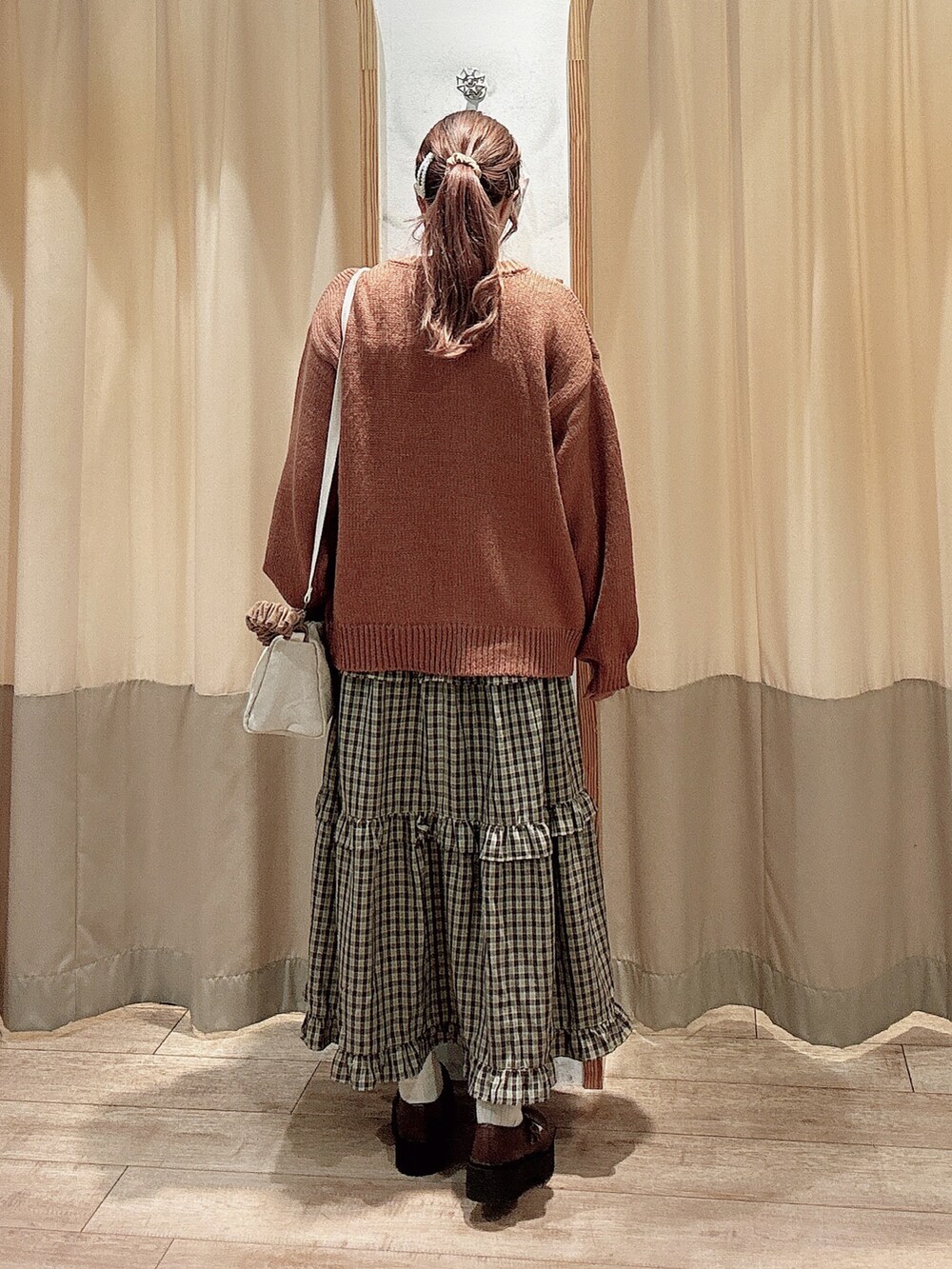 レッド系のカーディガン/ボレロ、レッド系のスカート、ブラウン系のその他シューズを着用したレディースの秋コーディネートの3枚目の写真