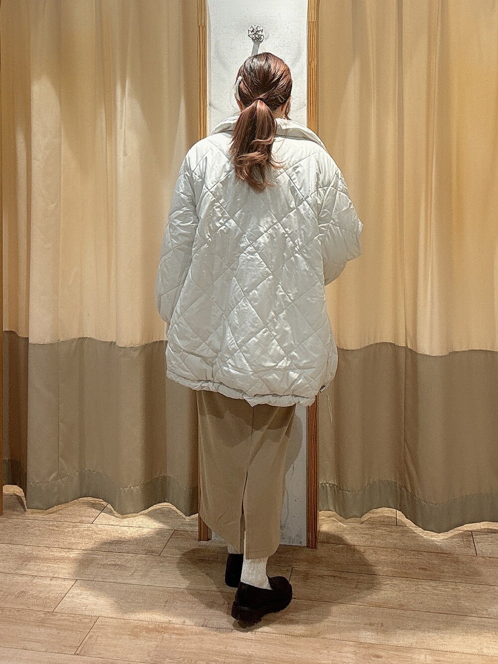 ホワイト系のTシャツ/カットソー、ピンク系のニット/セーター、ベージュ系のスカートを着用したレディースの冬コーディネートの2枚目の写真