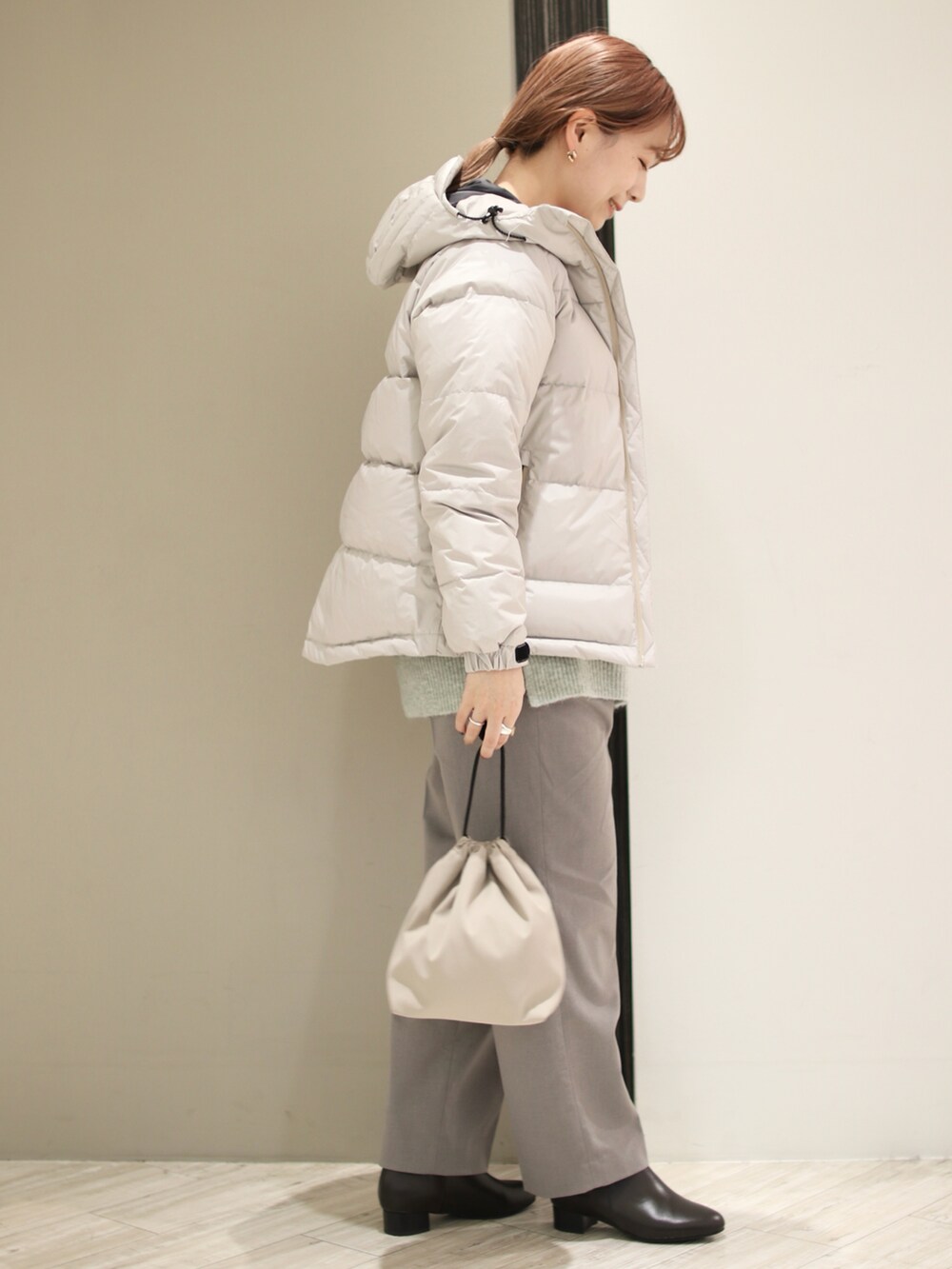 グレー系のその他パンツ、ブラウン系のブーツ、グリーン系のニット/セーターを着用したレディースの冬コーディネートの3枚目の写真