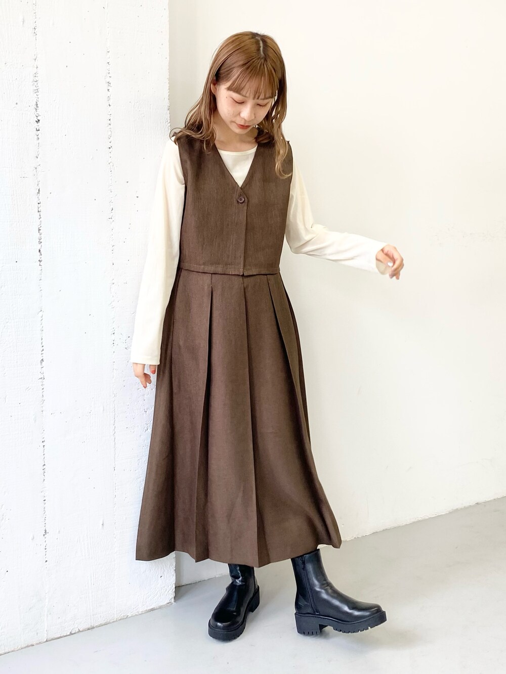 ブラウン系のワンピース、ブラック系のブーツを着用したレディースの秋コーディネートの2枚目の写真