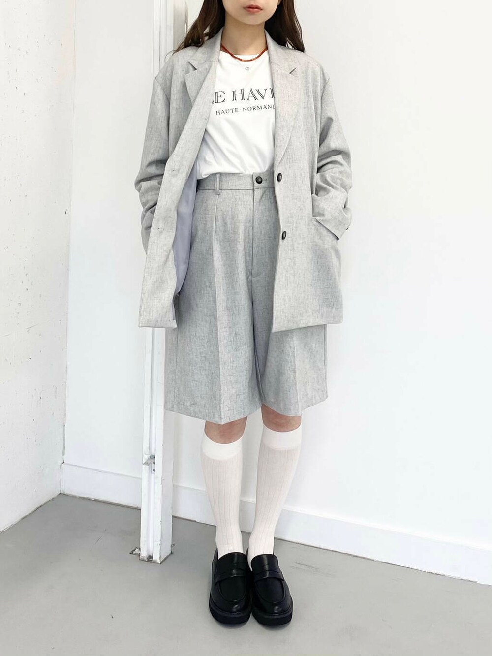 ブラック系のローファー、グレー系のその他パンツ、レッド系のネックレスを着用したレディースの春コーディネートの2枚目の写真