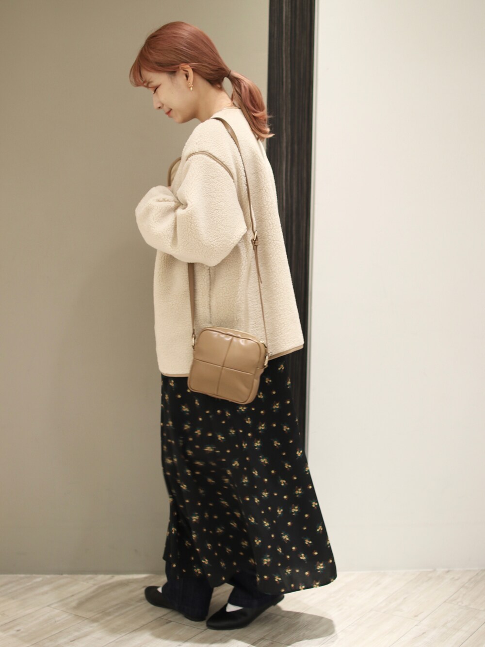 ホワイト系のブルゾン、ブラック系のワンピース、イエロー系のショルダーバッグを着用したレディースの秋コーディネートの3枚目の写真