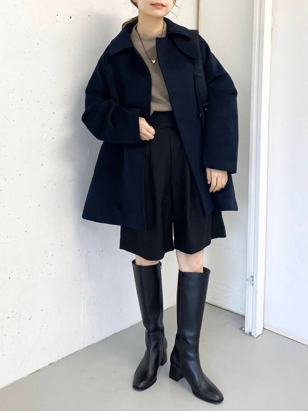 ブラック系のショルダーバッグ、ベージュ系のニット/セーター、ブラック系のその他パンツを着用したレディースの冬コーディネートの7枚目の写真