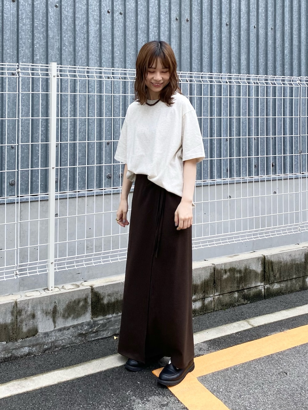 ブラウン系のスカート、ホワイト系のTシャツ/カットソーを着用したレディースの夏コーディネートの2枚目の写真