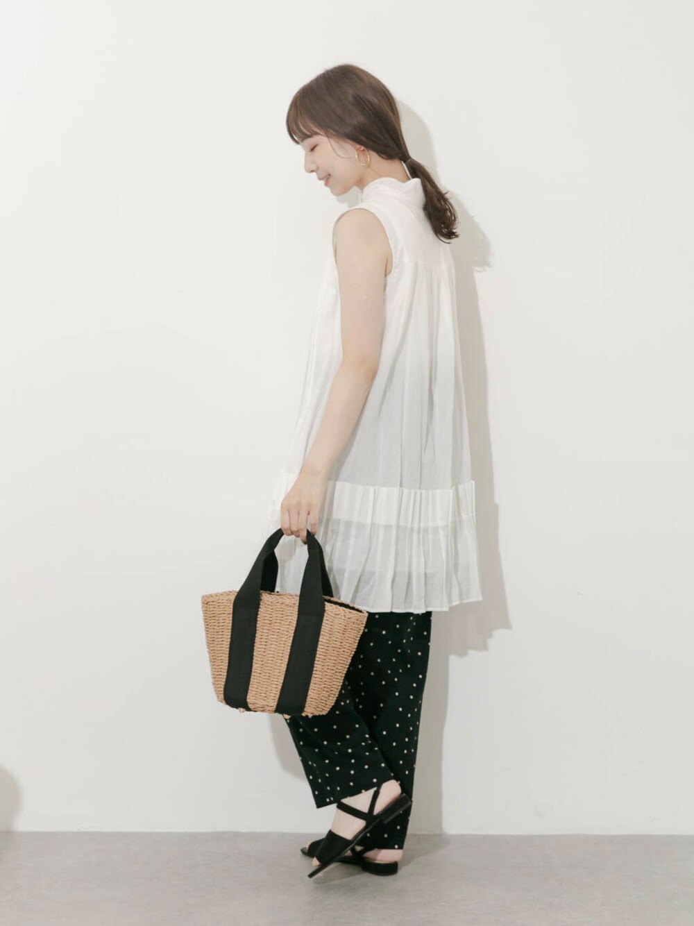 ベージュ系のハンドバッグ、ブラック系のその他パンツ、ホワイト系のワンピースを着用したレディースの夏コーディネートの3枚目の写真
