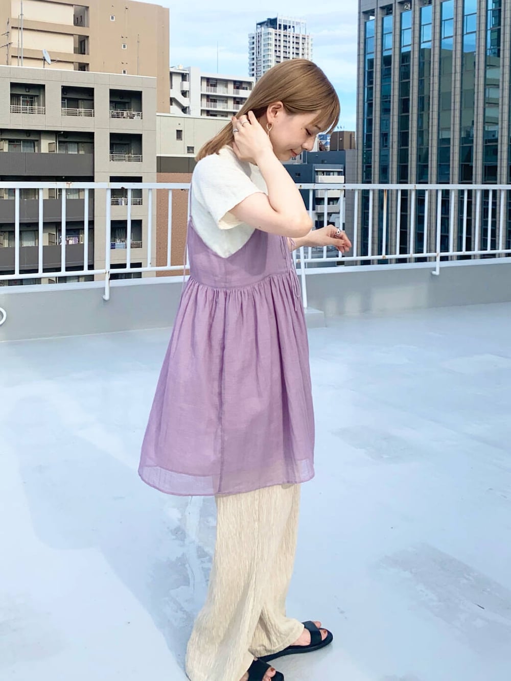 ベージュ系のその他パンツ、ホワイト系のTシャツ/カットソー、ブラック系のサンダルを着用したレディースの夏コーディネートの4枚目の写真
