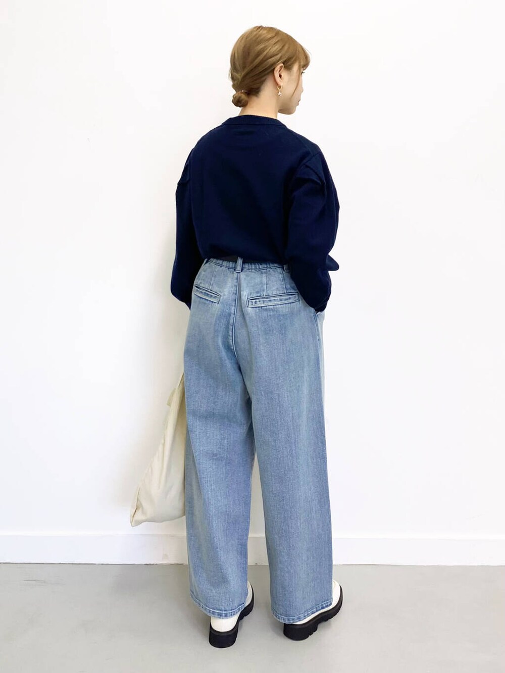 ホワイト系のローファー、ブルー系のデニムパンツ、ホワイト系のトートバッグを着用したレディースの冬コーディネートの3枚目の写真