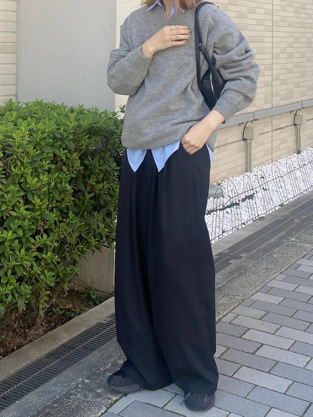 ブルー系のシャツ/ブラウス、ブラック系のボストンバッグ、グレー系のニット/セーターを着用したレディースの秋コーディネートの8枚目の写真