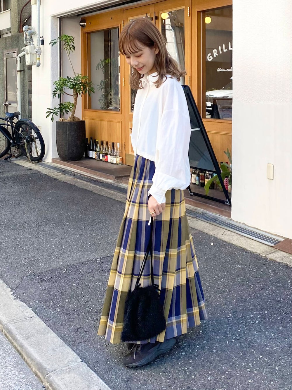 グレー系のスニーカー、ホワイト系のシャツ/ブラウス、ブルー系のスカートを着用したレディースの秋コーディネートの5枚目の写真