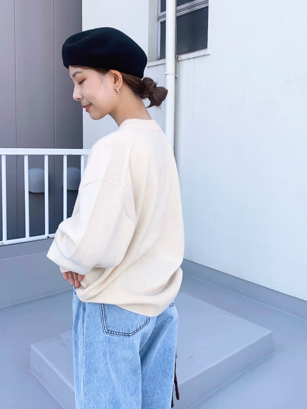 ブルー系のデニムパンツ、ブラック系のバレエシューズ、ホワイト系のカーディガン/ボレロを着用したレディースの冬コーディネートの3枚目の写真