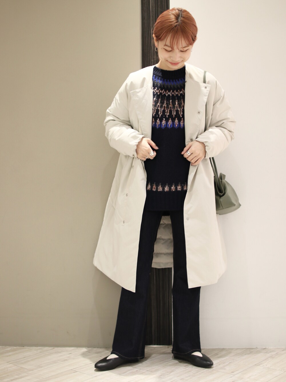 ブルー系のデニムパンツ、グリーン系のショルダーバッグ、ブルー系のニット/セーターを着用したレディースの秋コーディネートの2枚目の写真