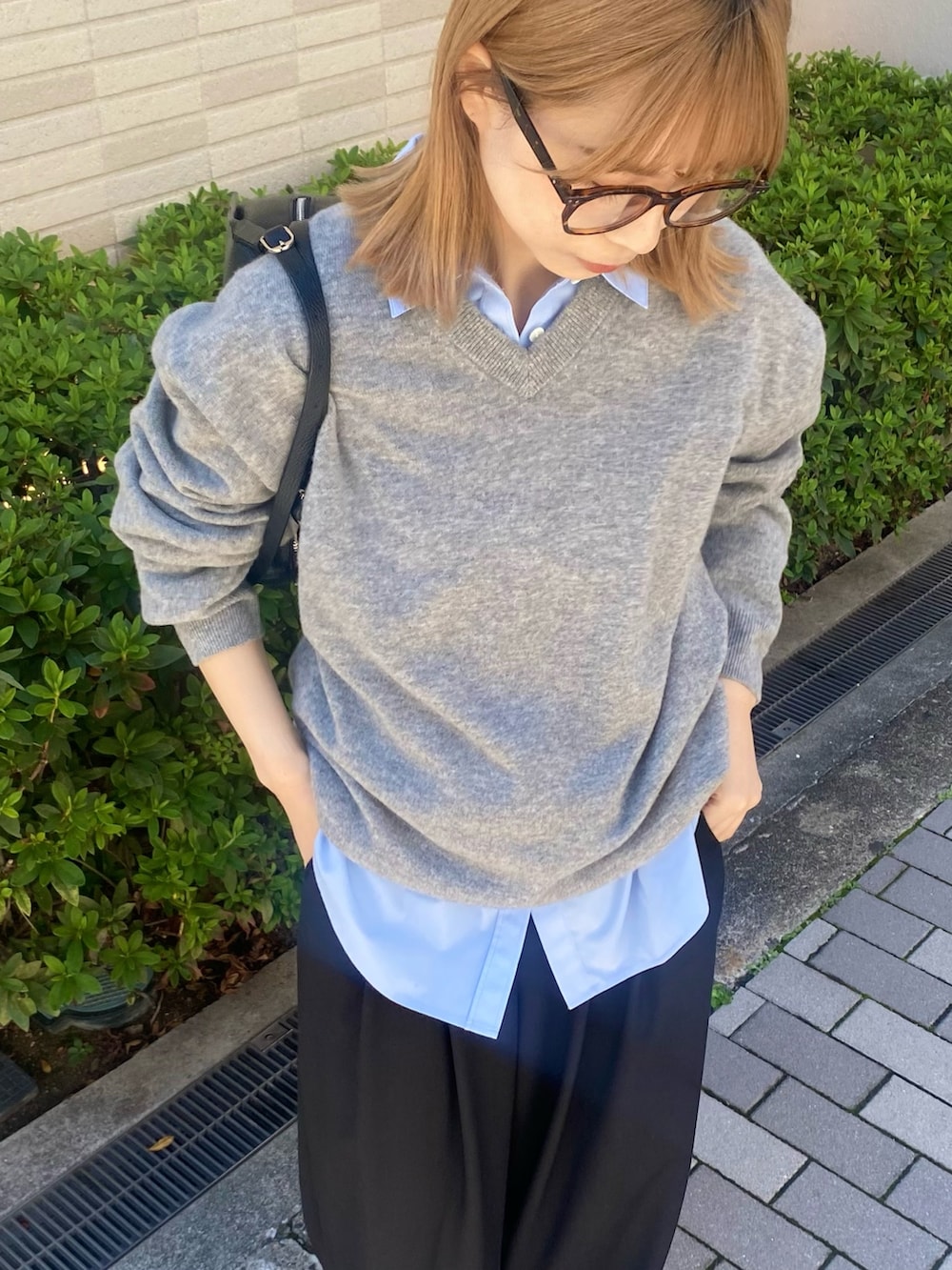ブルー系のシャツ/ブラウス、ブラック系のボストンバッグ、グレー系のニット/セーターを着用したレディースの秋コーディネートの6枚目の写真