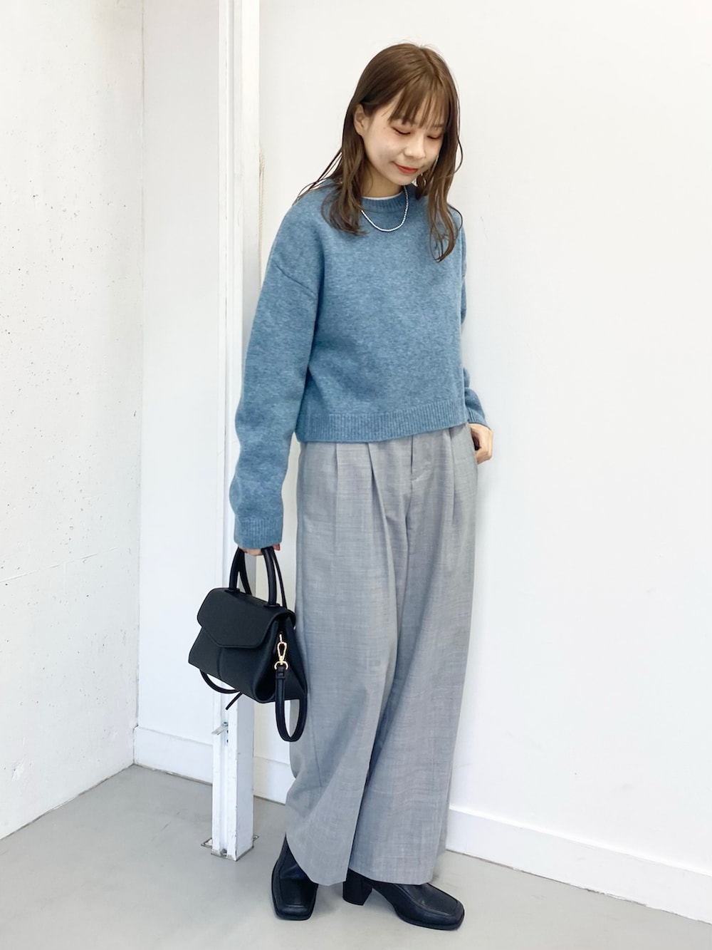 ブラック系のブーツ、グレー系のその他パンツ、ブラック系のショルダーバッグを着用したレディースの冬コーディネートの2枚目の写真