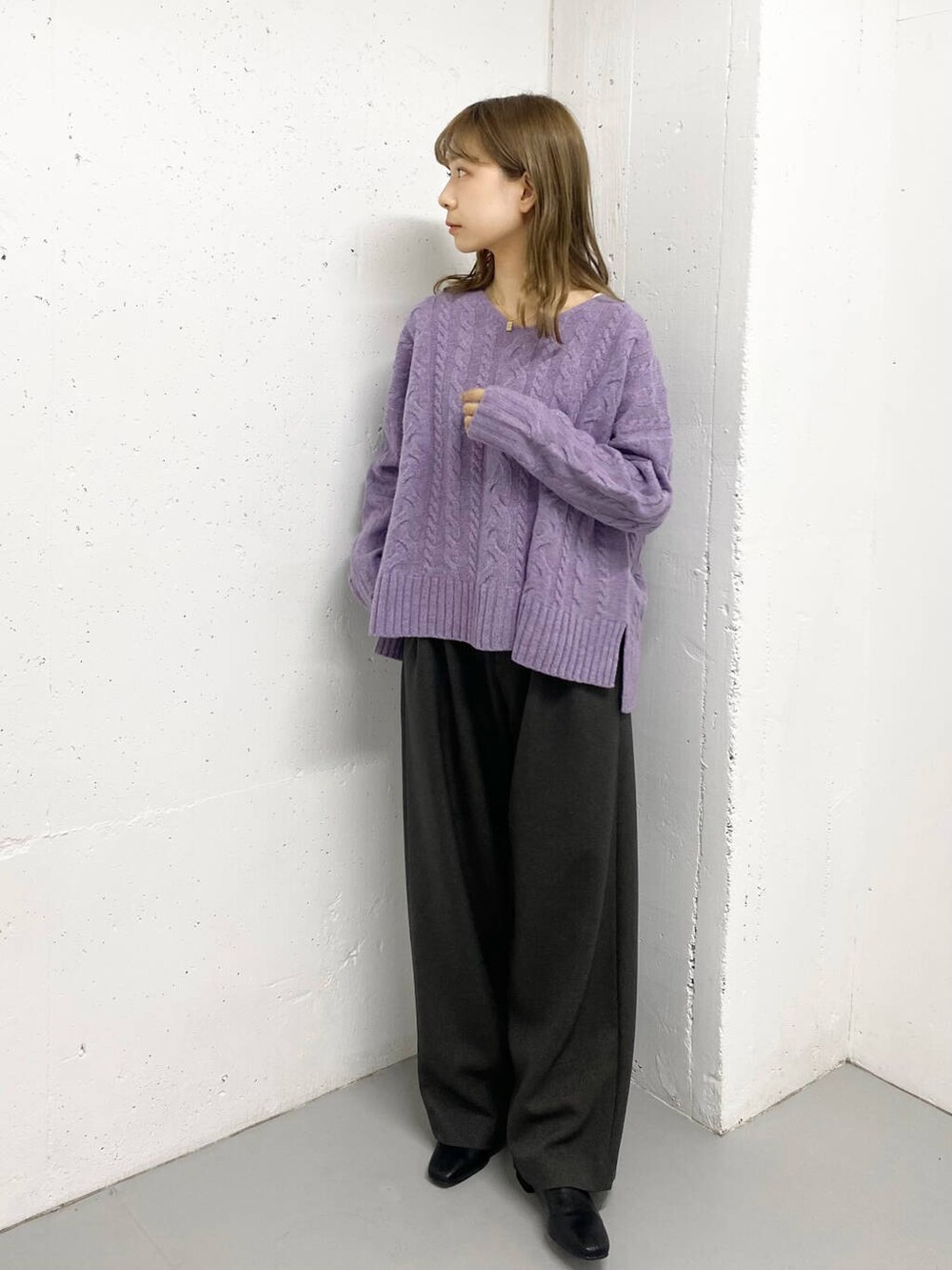 パープル系のニット/セーター、グレー系のその他パンツ、ブラック系のブーツを着用したレディースの秋コーディネートの2枚目の写真