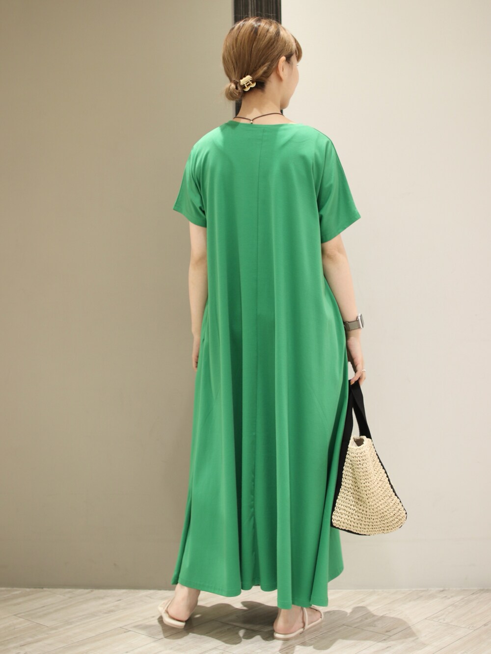 ベージュ系のトートバッグ、ホワイト系のサンダル、グリーン系のワンピースを着用したレディースの夏コーディネートの4枚目の写真