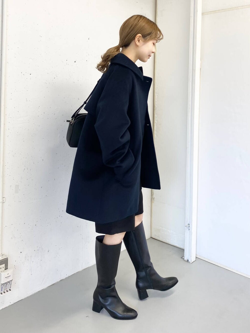 ブラック系のショルダーバッグ、ベージュ系のニット/セーター、ブラック系のその他パンツを着用したレディースの冬コーディネートの6枚目の写真