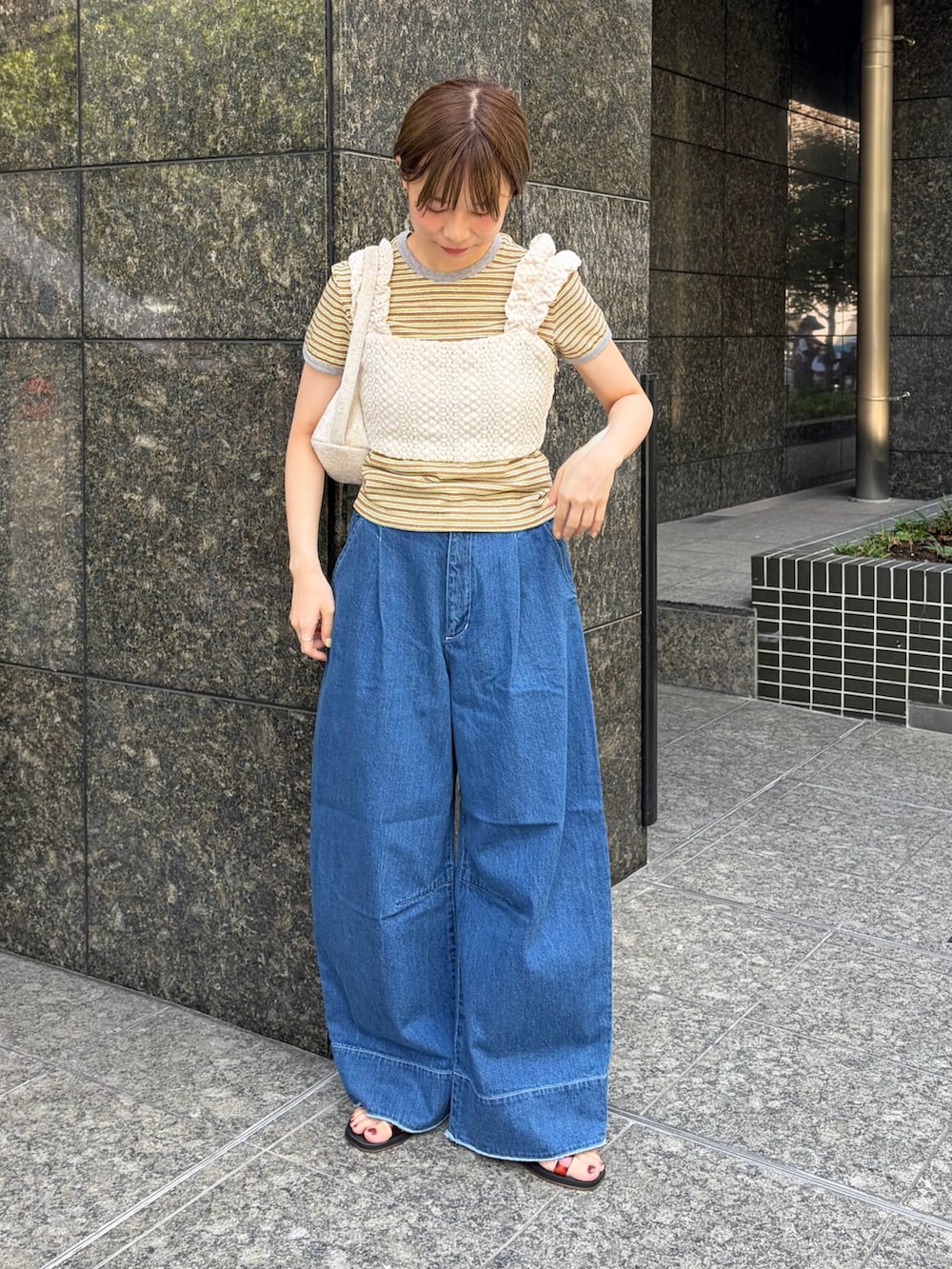 ホワイト系のハンドバッグ、ホワイト系のニット/セーター、イエロー系のTシャツ/カットソーを着用したレディースの秋コーディネートの4枚目の写真