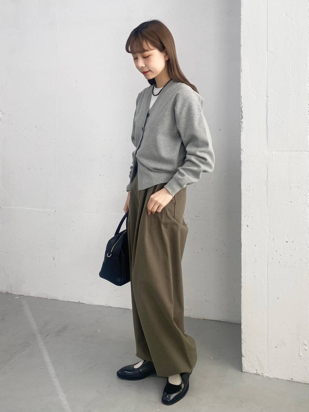 ブラック系のボストンバッグ、ブラック系のローファー、グレー系のカーディガン/ボレロを着用したレディースの春コーディネートの6枚目の写真