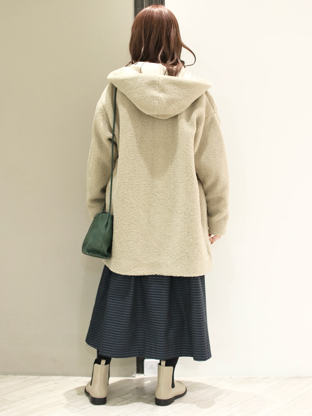 ブルー系のワンピース、ベージュ系のその他アウター、ベージュ系のブーツを着用したレディースの冬コーディネートの3枚目の写真