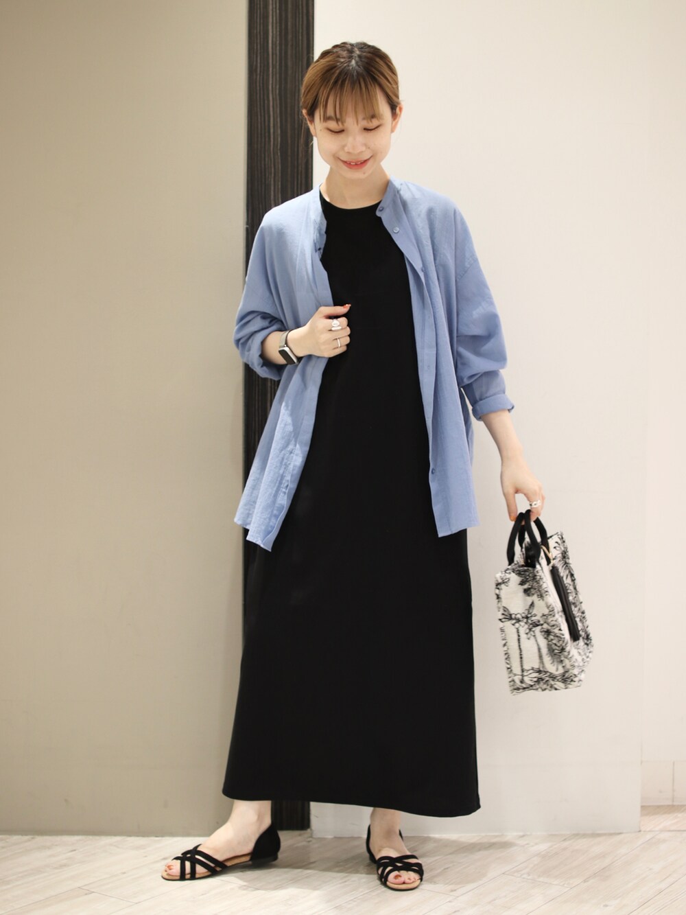 ブルー系のシャツ/ブラウス、ブラック系のワンピース、ブラック系のトートバッグを着用したレディースの夏コーディネートの2枚目の写真